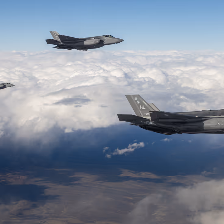 Drie F-35’s vliegend boven een wolkendek.