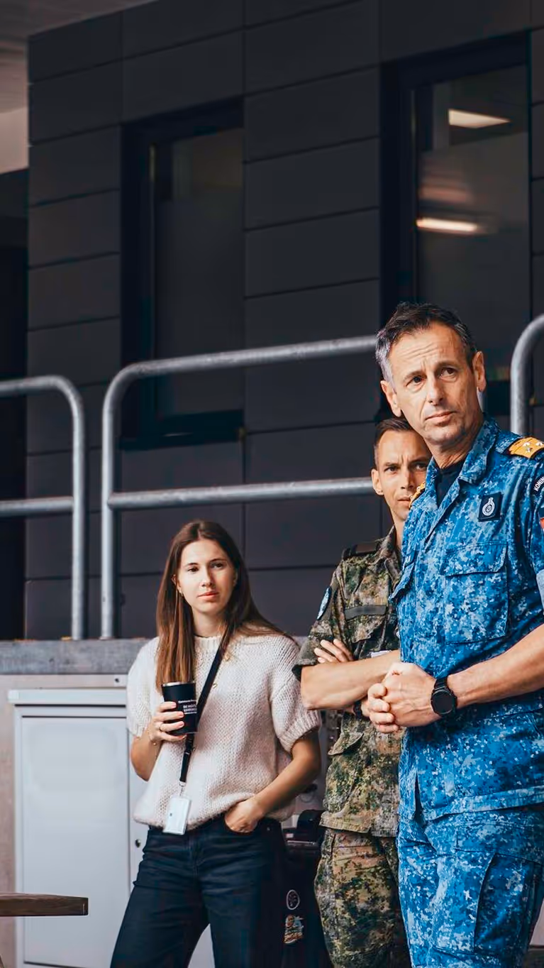 C-COMMIT Jan-Willem Hartman in blauw gevechtstenue omringd door personeel. 