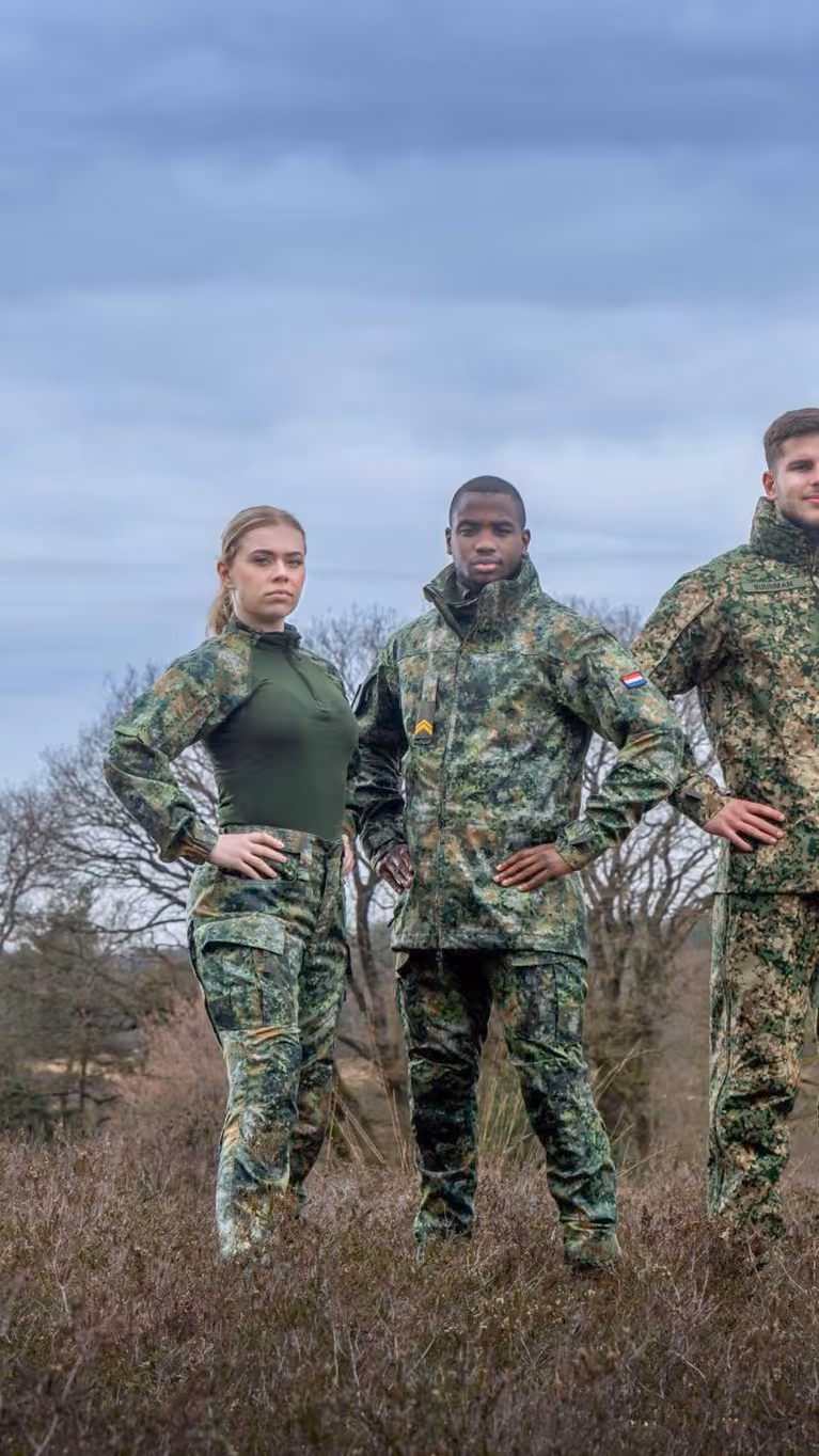 Vier militairen staan in het veld.