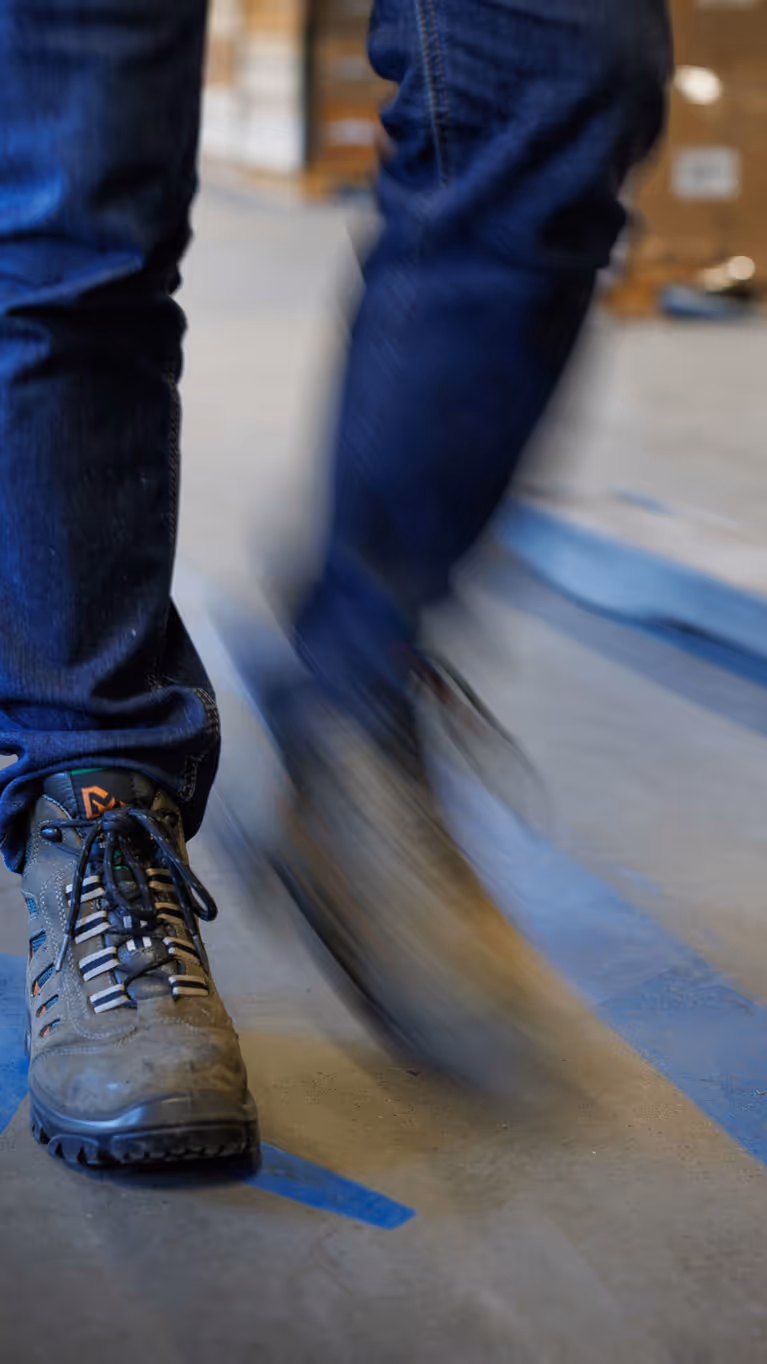 Een persoon met wandelschoenen beweegt zich langs een blauwe lijn. Daarnaast is een blauw poppetje afgebeeld, om aan te geven waar je mag lopen. 