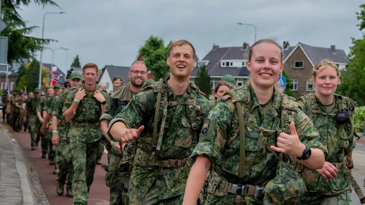 Een aantal militairen groet de fotograaf tijdens een wandeling.