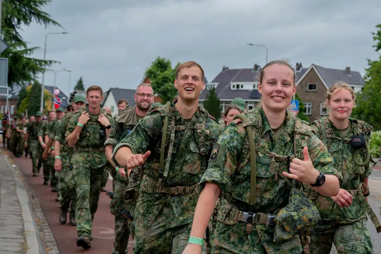 Vrolijke militairen lopen de vierdaagse.