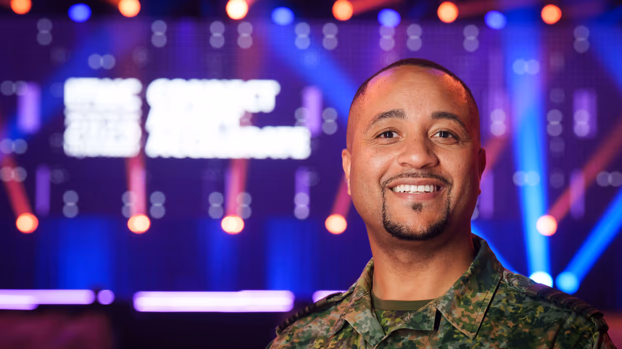 Volle conferentiezaal met lichtshow.