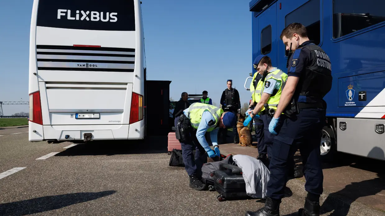 Marechaussees zijn bezig met een controle, op de achtergrond een Flixbus.