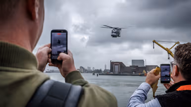 Een helikopter vliegt boven het water.