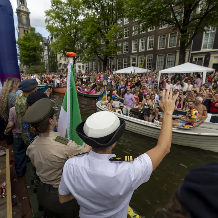 Militairen en burgermedewerkers op een boot bij de Canal Parade.