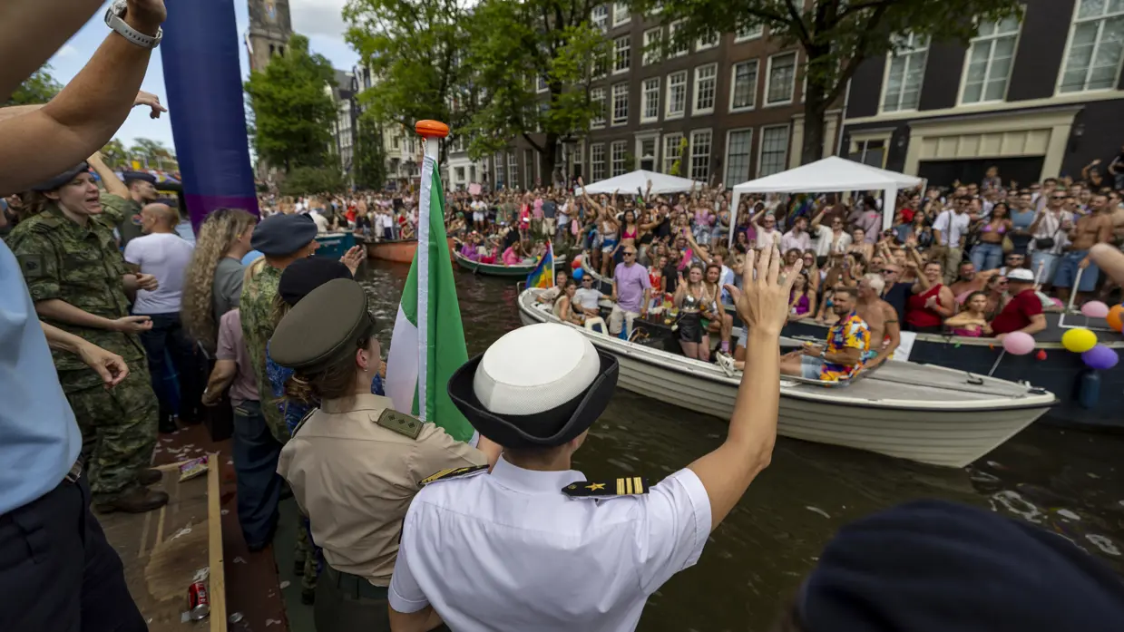Militairen en burgermedewerkers op een boot bij de Canal Parade.