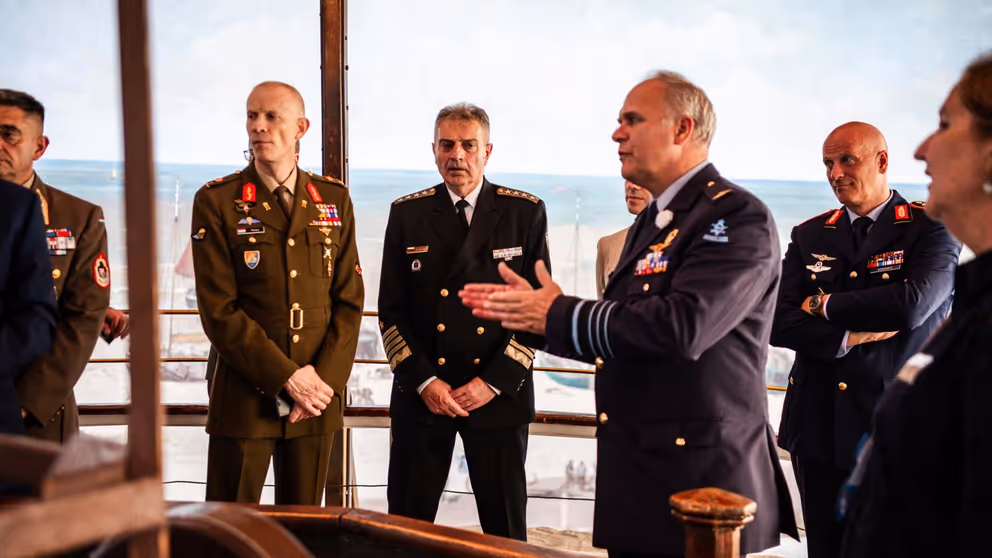 De generaal praat tegen collega's.