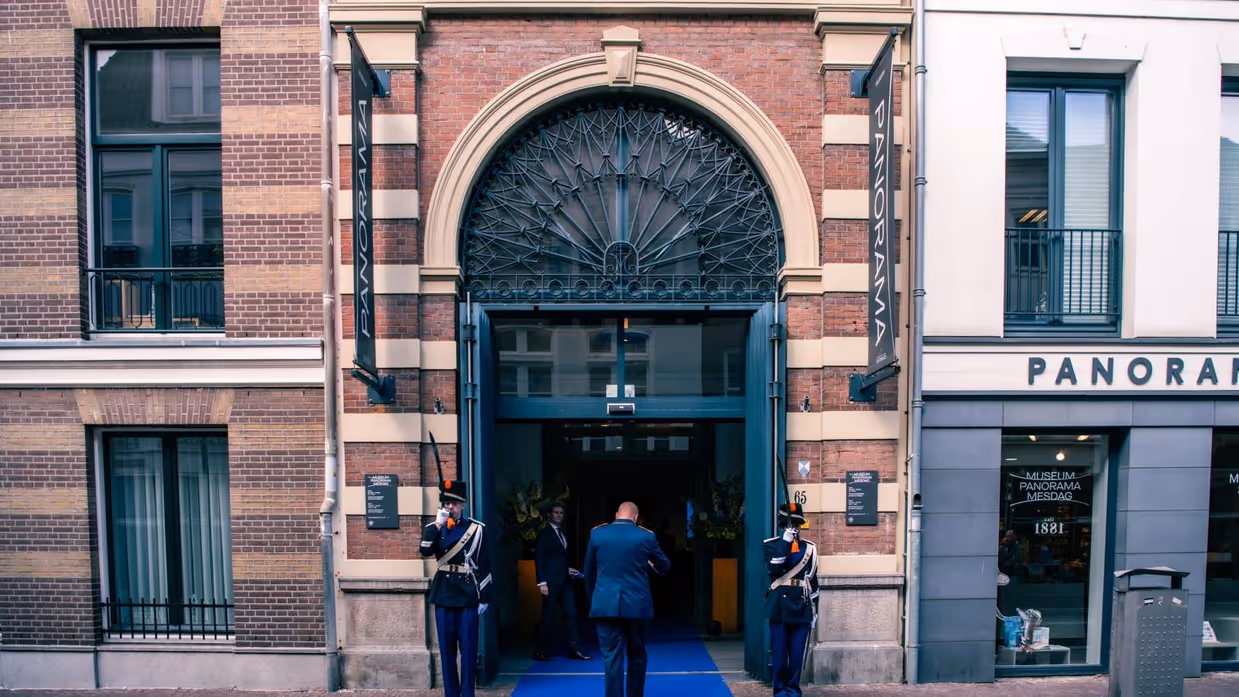 Twee militairen vormen een erewacht bij een entree.