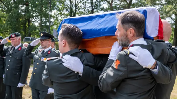 Militairen brengen de eregroet als de stoffelijke resten van soldaat Klink voorbij komen.