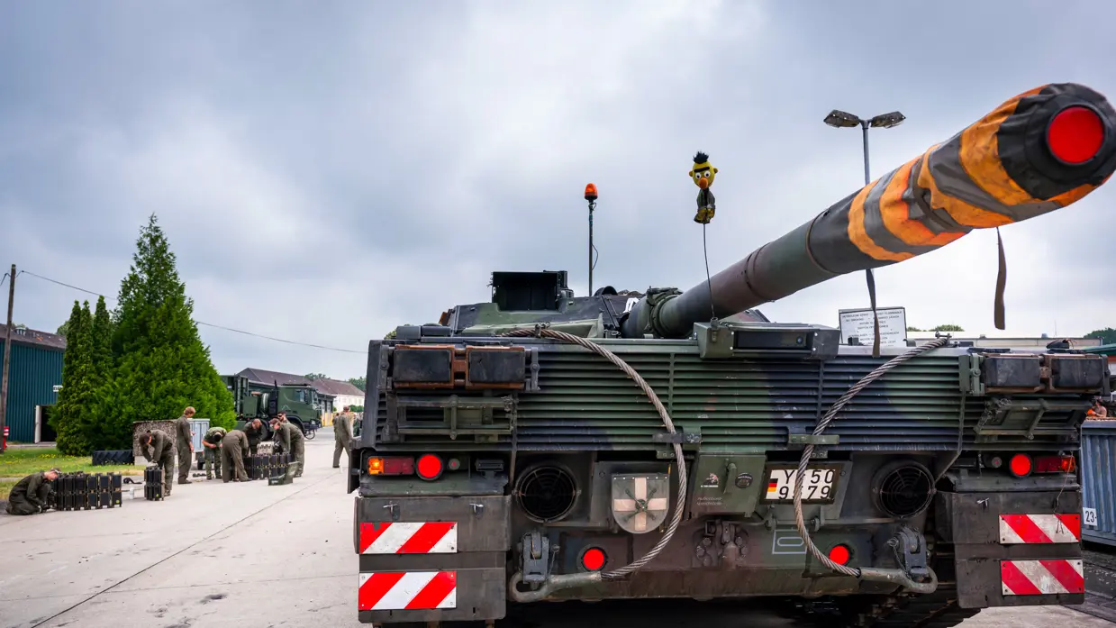 Tank met een pop van Bert uit Sesamstraat, aan de zijkant werken militairen.