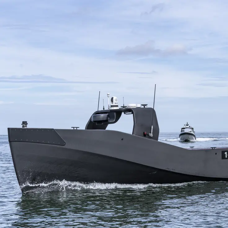 Een grijs-zwart onbemand vaartuig op zee.