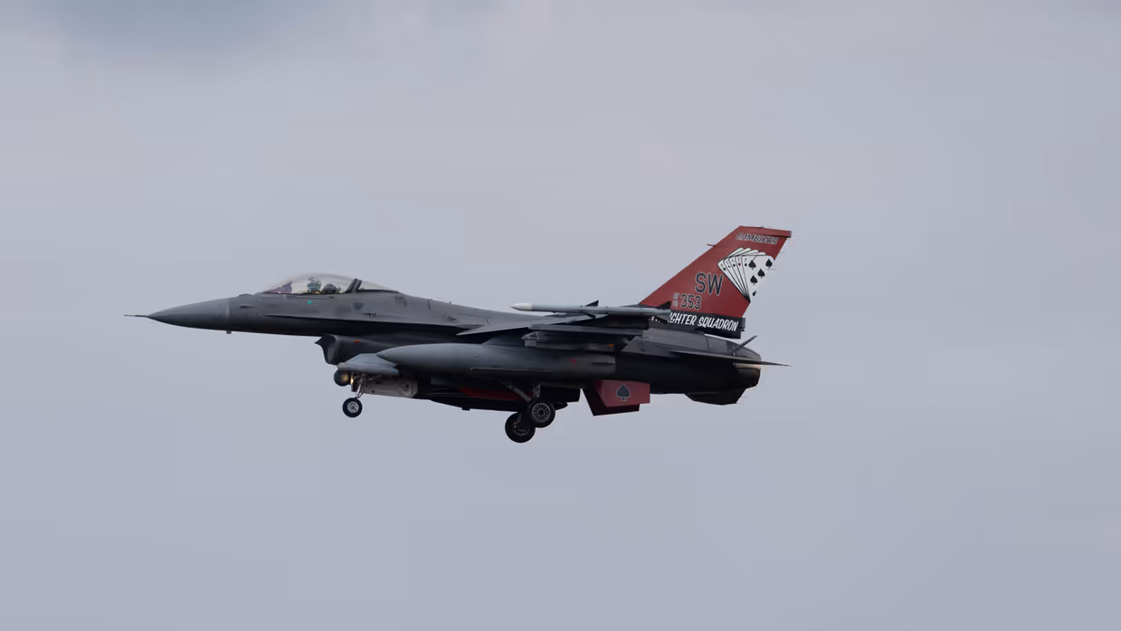 Een F-16 in de landing onder een blauwe lucht. 