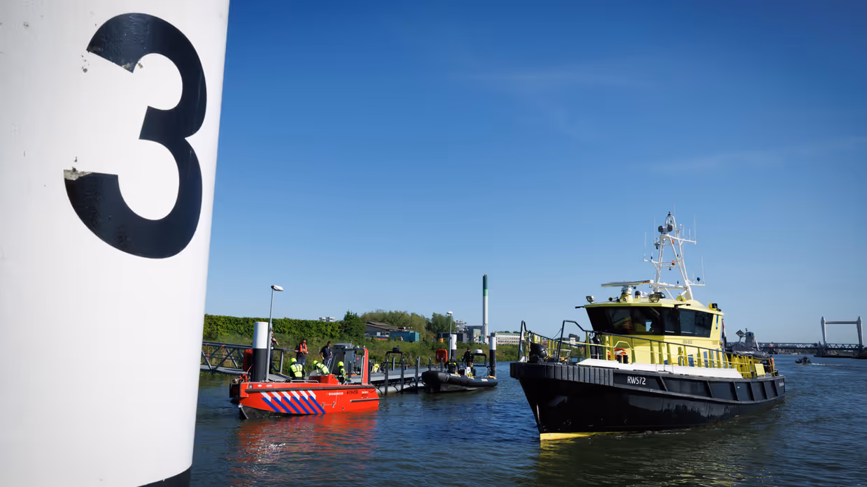 Vaartuigen van de brandweer en Rijkswaterstaat op het water. 