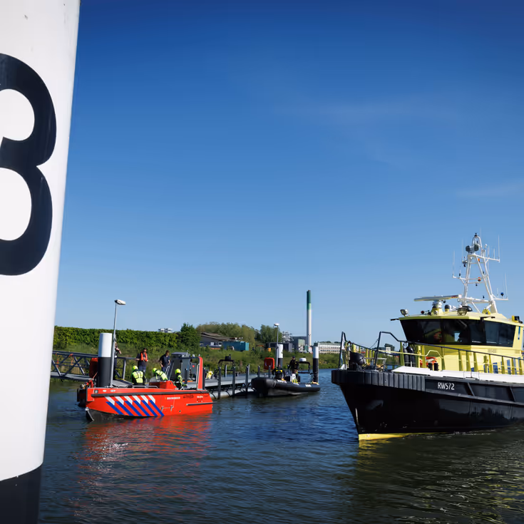 Vaartuigen van de brandweer en Rijkswaterstaat op het water. 