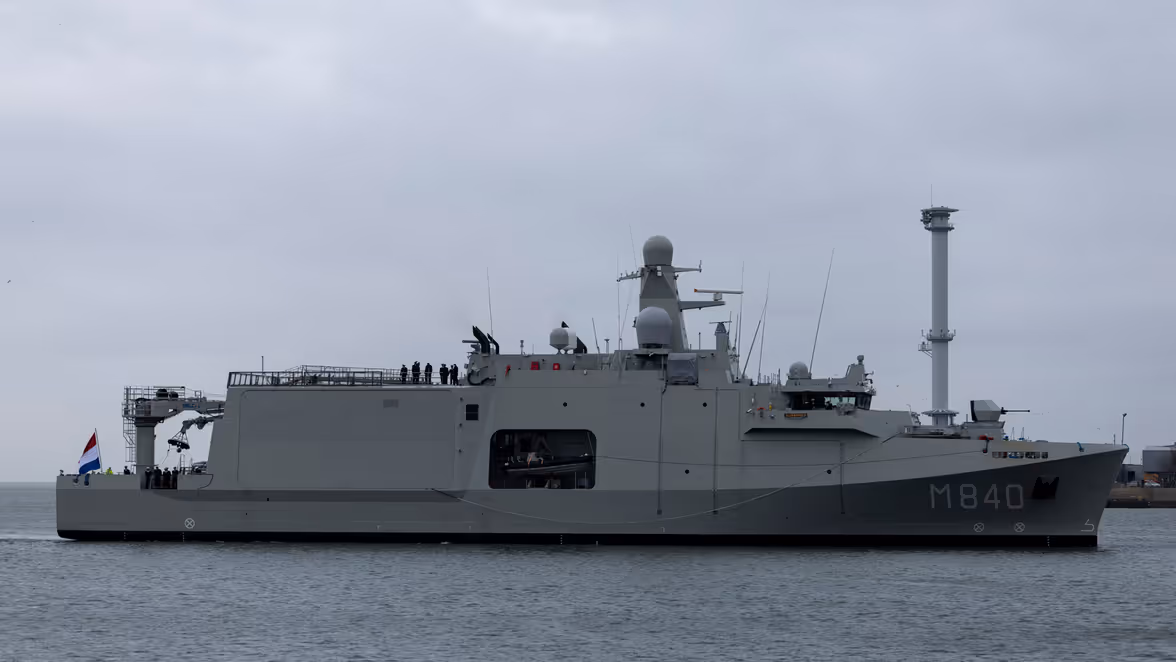 Een grijs marineschip vanaf de zijkant. Hier staat in witte letters ‘M840’ op. 