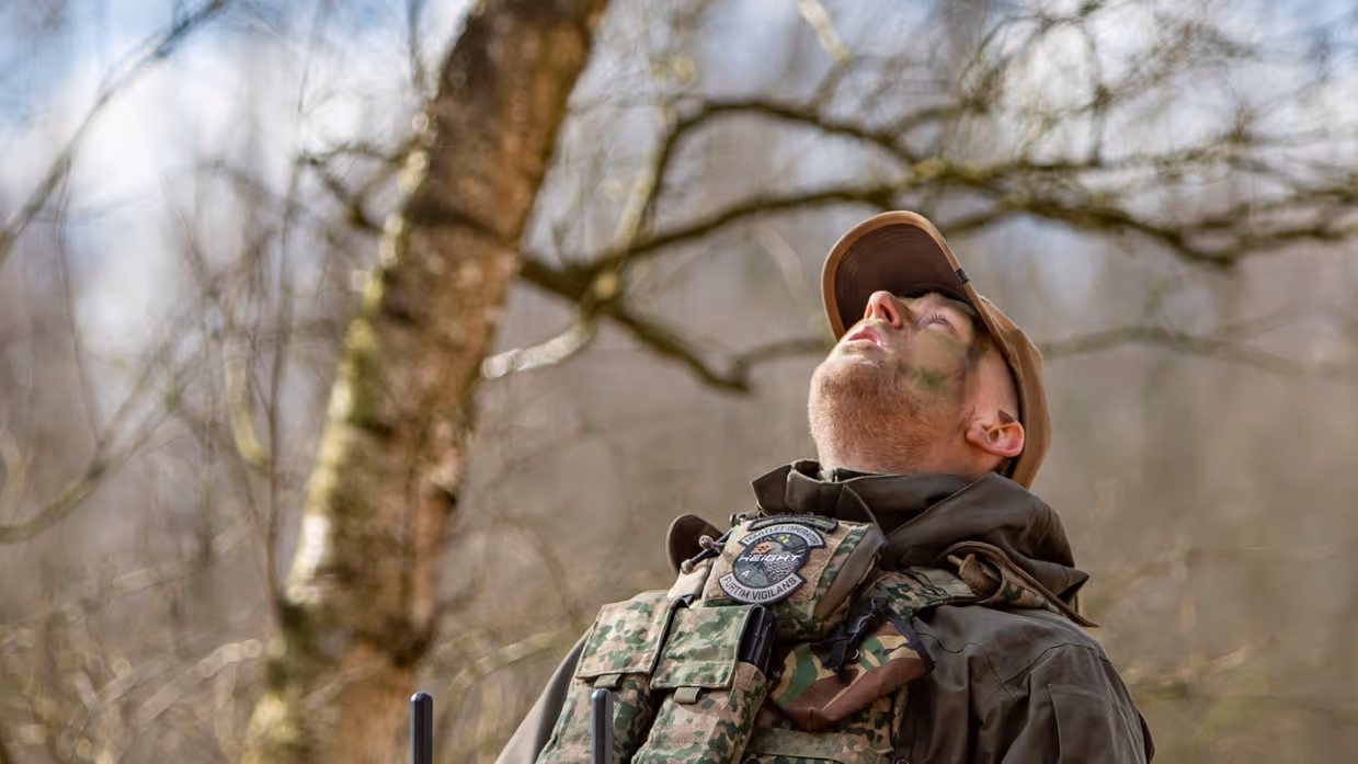 Militair bestuurt een drone met een controller tijdens inzet in het veld. 