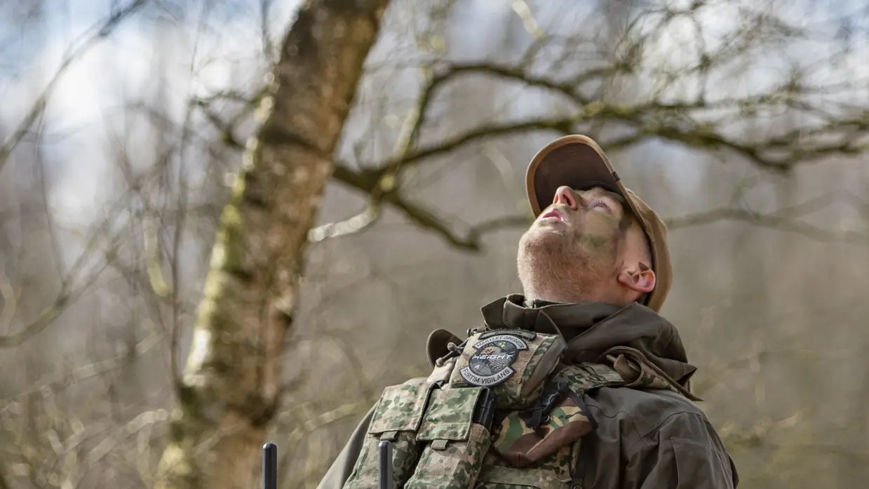 Militair bestuurt een drone met een controller tijdens inzet in het veld. 