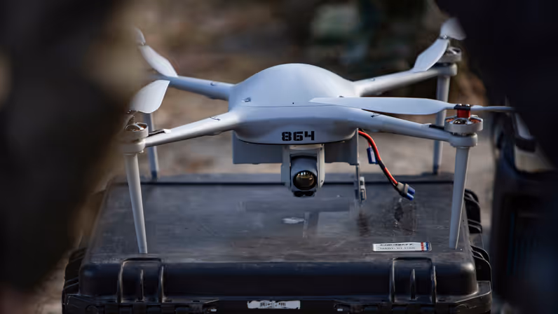 Drone met camera geplaatst op een transportkoffer, klaar voor inzet in het veld. 