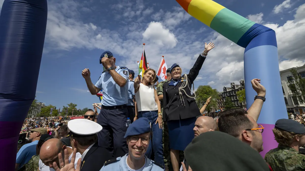 Militairen en burgermedewerkers op een boot bij de Canal Parade.