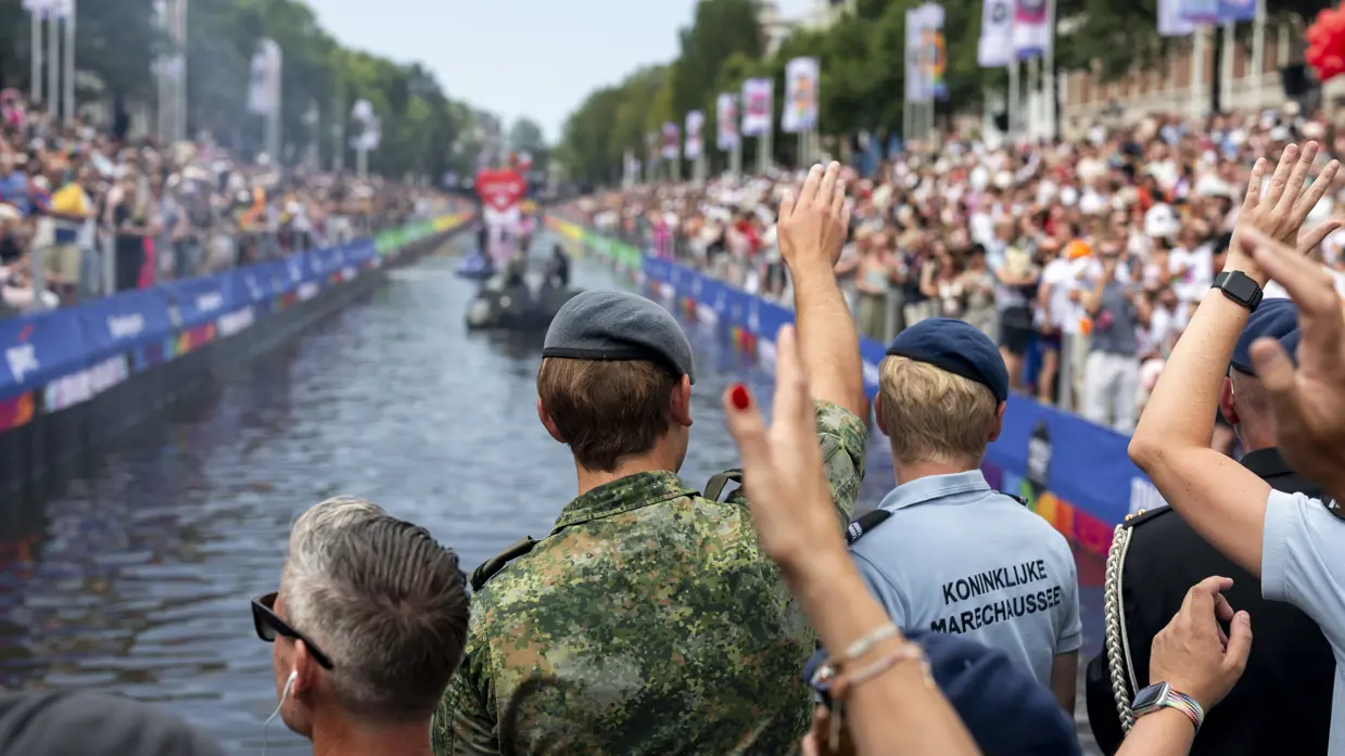 Militairen en burgermedewerkers op een boot bij de Canal Parade.