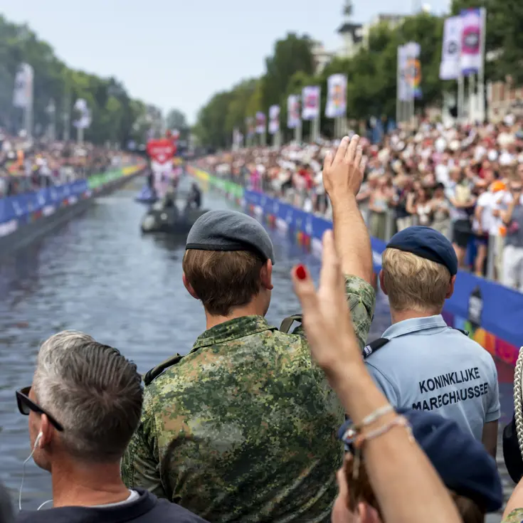 Militairen en burgermedewerkers op een boot bij de Canal Parade.