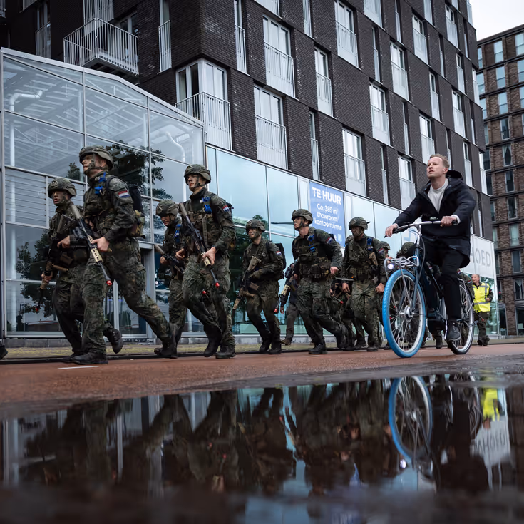 De deelnemers aan de NWT marcheren door Amsterdam.