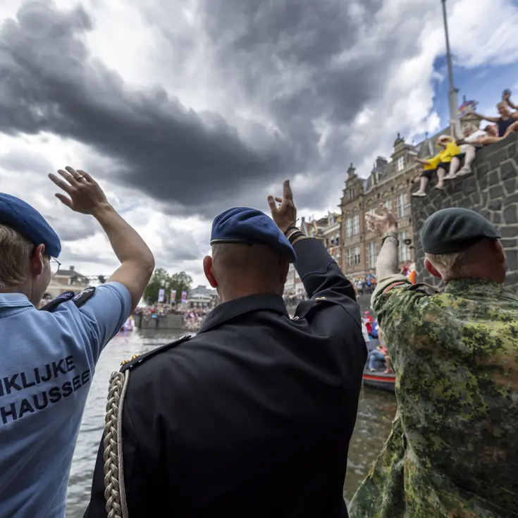 Militairen en burgermedewerkers op een boot bij de Canal Parade.