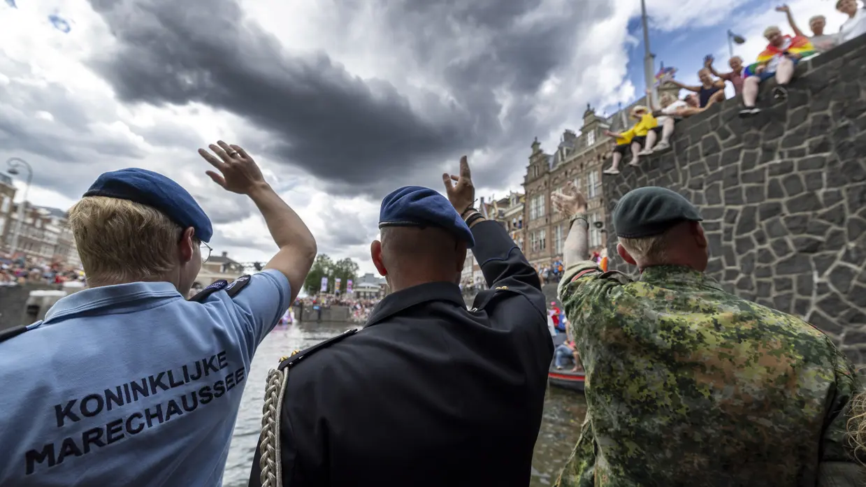 Militairen en burgermedewerkers op een boot bij de Canal Parade.