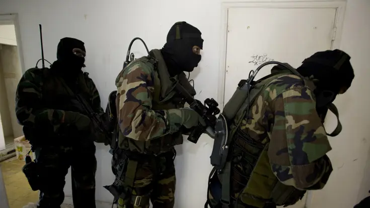 Speciale teams doorzoeken gebouw op terroristen.