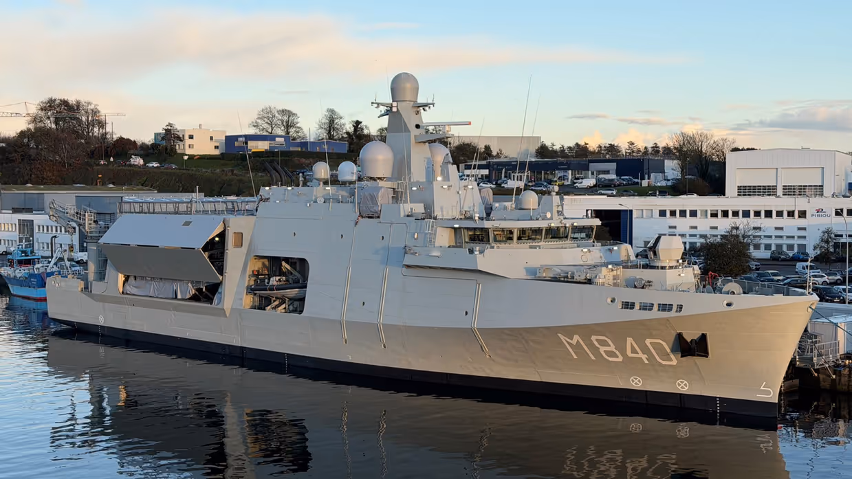 Het grijze marineschip ‘Vlissingen’ aan de wal. Aan de zijkant is in grote, witte letteers ‘M840’ te lezen.