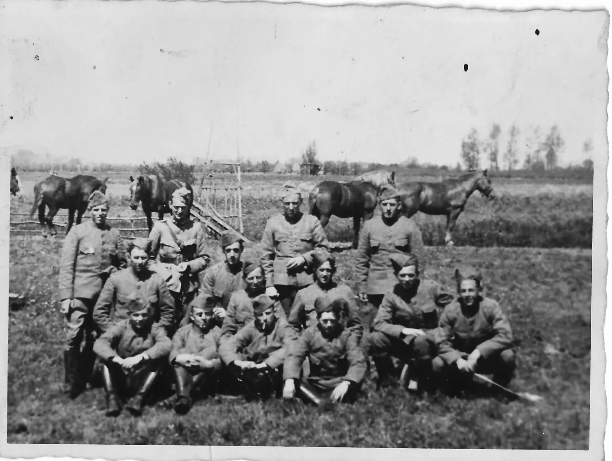 Zwart-witgroepsfoto militairen in weiland met paarden.
