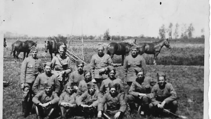 Zwart-witgroepsfoto militairen in weiland met paarden.