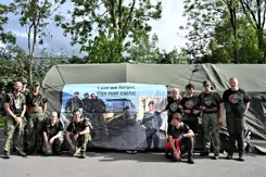 Militairen poseren voor een spandoek.