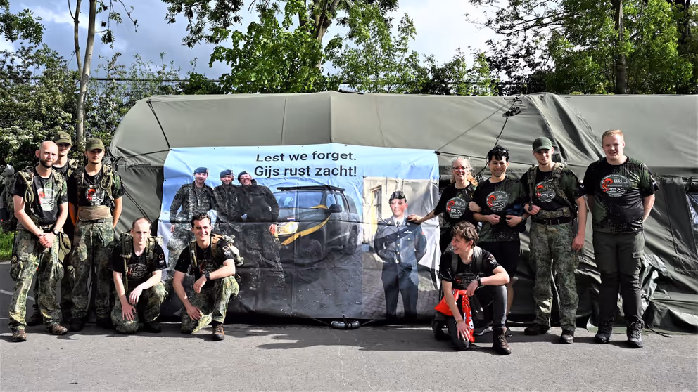 Militairen poseren voor een spandoek.
