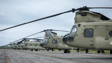 Een rij Chinooks opgesteld. Daarnaast een rij Apaches opgesteld. 
