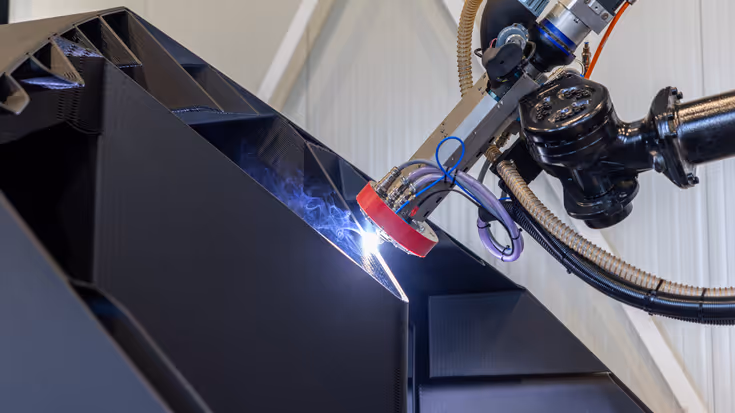 Een robot last een onderdeel van een 3D-geprinte boot.