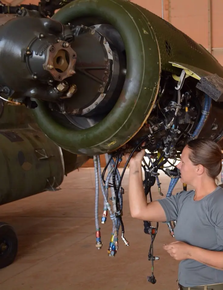Vrouw verricht onderhoud aan een helikopter.