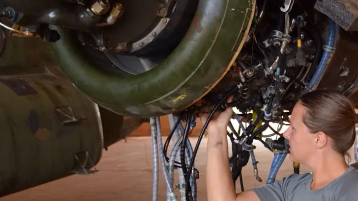 Vrouw verricht onderhoud aan een helikopter.