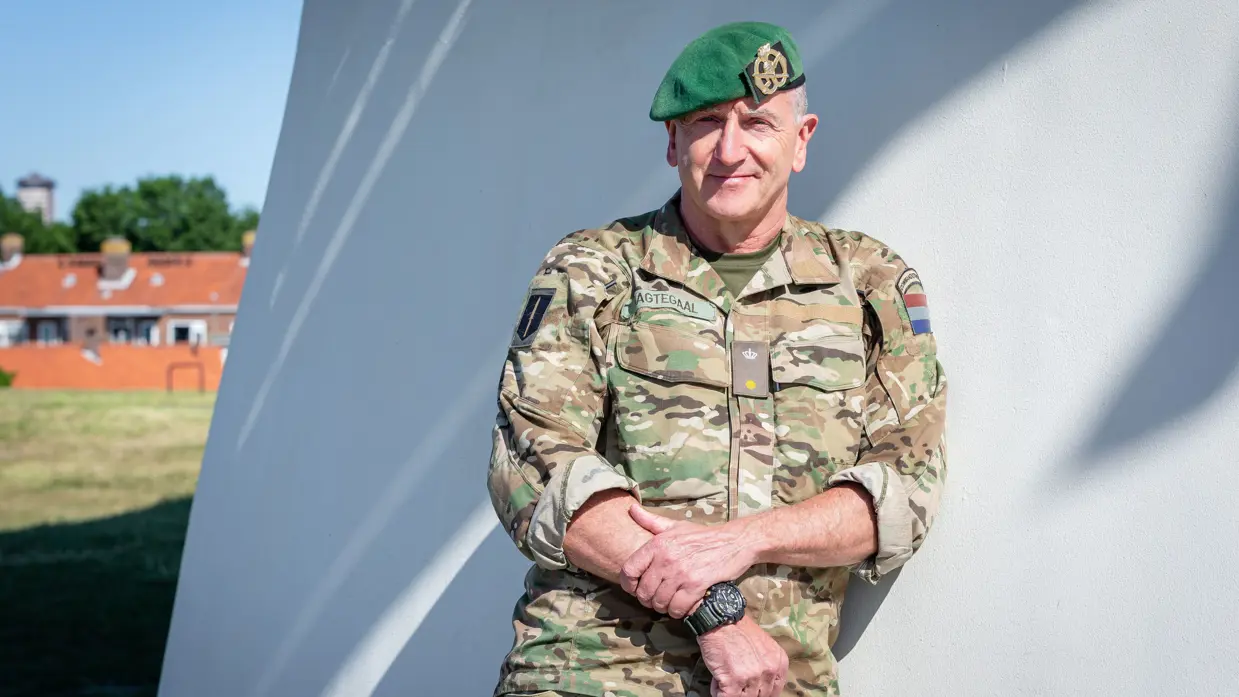 Dre Nagtegaal leunt op een witte muur.