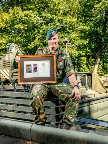 Kapitein René met de lijst waarin opa's Mobilisatie-Oorlogskruis zit.