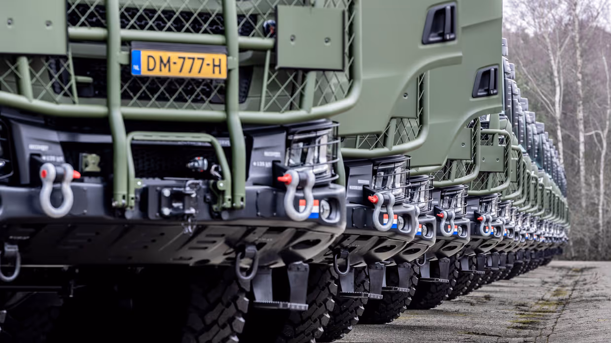 Een groot aantal vrachtwagens in een lange rij.