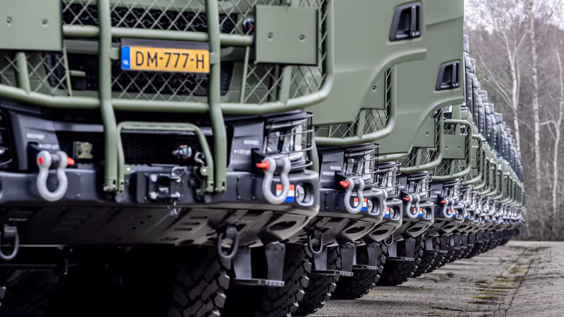 Een groot aantal vrachtwagens in een lange rij.