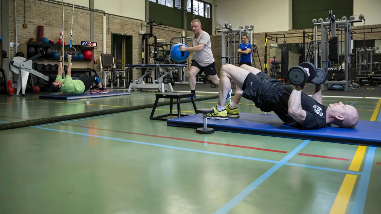 4 personen aan het sporten in een gymzaal.