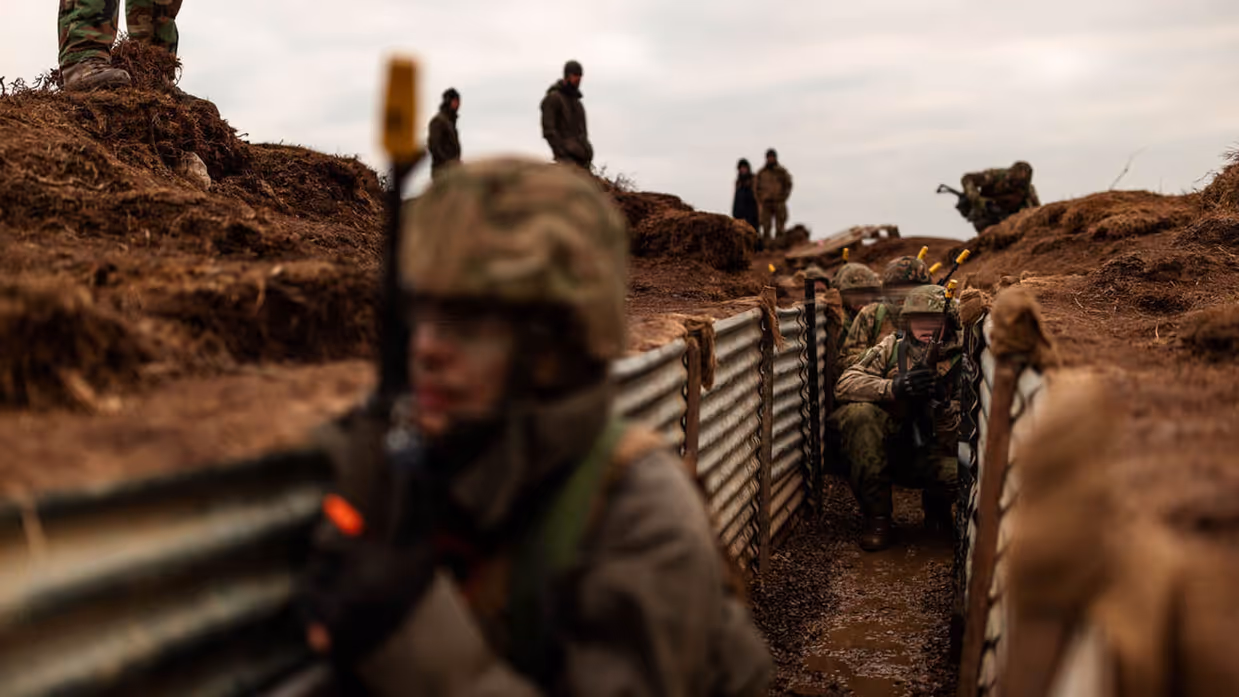 Militairen trainen in een loopgraaf.