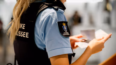 Vrouwelijke marechaussee controleert paspoort.