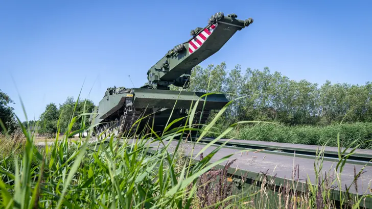 Brugleggende tank rijdt over brug.