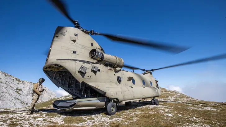 Gelande Chinook in bergen met geopende achterklep.