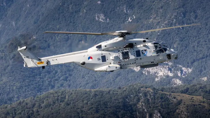 Zijaanzicht helikopter vliegend tussen de bergen.