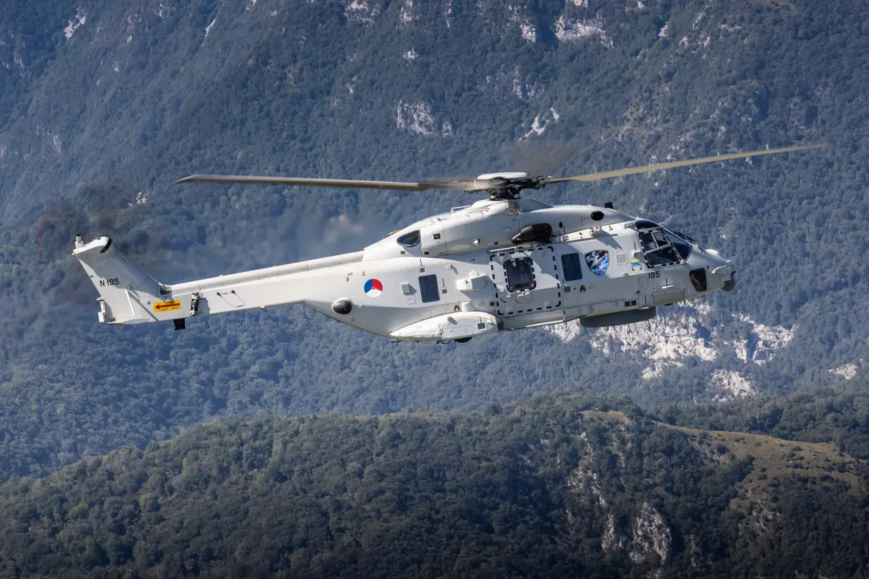 Zijaanzicht helikopter vliegend tussen de bergen.